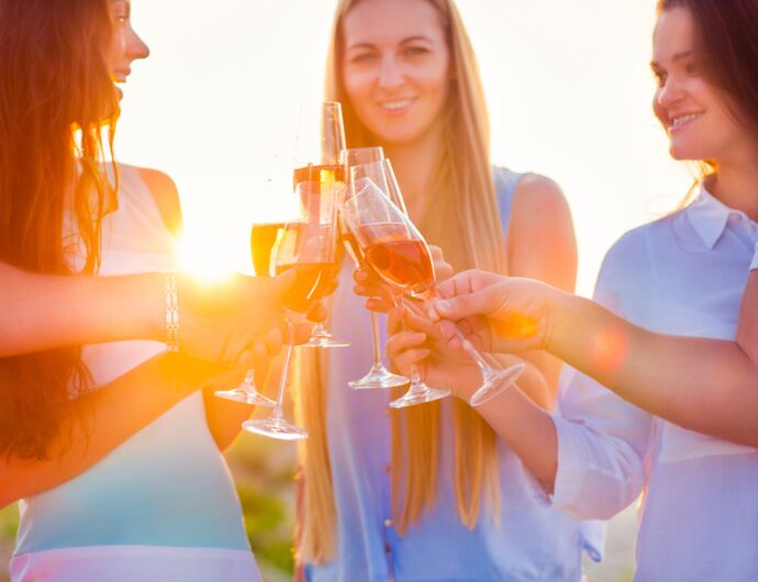 Group of friends toasting champagne sparkling wine at a relax party celebration gathering at the beach